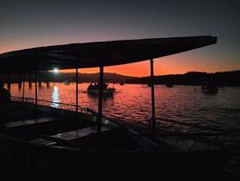 erstaunlich Aussicht von Silhouette von ein Boot und Sonnenuntergang foto