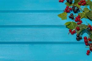 frisch Beeren und Blätter auf ein hölzern Blau Hintergrund foto