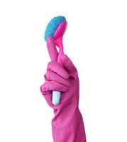 Hand im ein Rosa Gummi Handschuh zum Reinigung ein Haus hält Plastik Bürste mit ein Griff foto