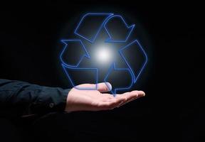 Blau glühend Recycling Zeichen schwebend über Hand, nachhaltig Entwicklung. Ökologie und Umgebung Konzept. foto