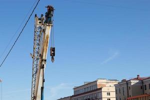 Konstruktion im das Stadt, Straße Reparatur funktioniert. Heben Kran und Himmel Hintergrund foto