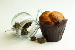 Muffin Kuchen mit Cannabis. thc Marihuana Knospen auf Weiß Hintergrund foto