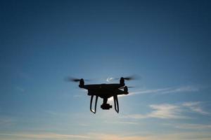 weiße Drohne, die in einem strahlend blauen Himmel schwebt foto
