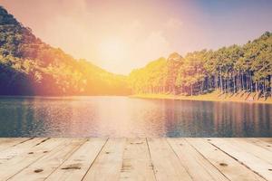 Holz Tabelle und Teich Wasser und Sonnenaufgang mit Jahrgang Wirkung. foto