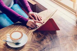 Frau mit Tablette Computer im Kaffee Geschäft mit Jahrgang Ton. foto