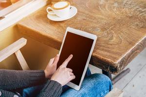 Frau abspielen Tablette Computer im Kaffee Geschäft mit Jahrgang getönt. foto