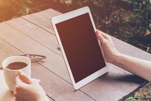 schließen oben Hand halten und mit Tablette im Kaffee Geschäft mit Jahrgang getönt. foto