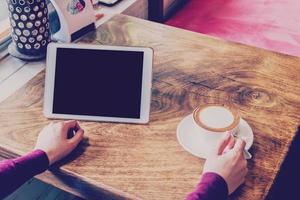 Frau mit Tablette Computer im Kaffee Geschäft mit Jahrgang Ton. foto