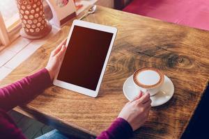 Frau mit Tablette Computer im Kaffee Geschäft mit Jahrgang Ton. foto