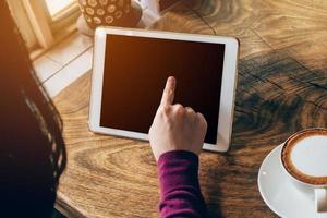 Frau mit Tablette Computer im Kaffee Geschäft mit Jahrgang Ton. foto