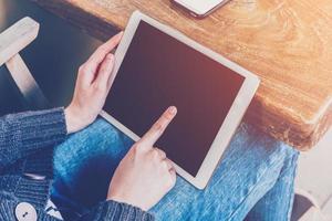 asiatisch Frau mit Tablette Computer im Kaffee Geschäft mit Jahrgang Ton. foto