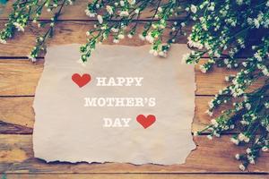 glücklich Mütter Tag auf braun Papier mit Weiß Blume auf hölzern Tafel foto