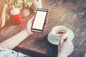 schließen oben von Hand Frau mit Telefon im Kaffee Geschäft mit Jahrgang getönt. foto