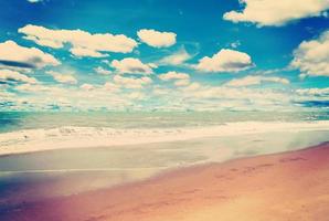 Sand Strand Meer und Blau Himmel Wolken mit Jahrgang Ton. foto