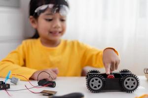 asia studenten lernen zu hause in der codierung von roboterautos und elektronischen platinenkabeln in stamm-, dampf-, mathematik-ingenieurwissenschaften-technologie-computercode im robotikkonzept für kinder. foto