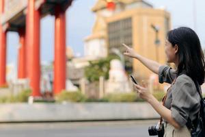 jung asiatisch Frau Rucksack Reisender genießen China Stadt, Dorf Straße Essen Markt im Bangkok, Thailand. Reisender Überprüfung aus Seite Straßen. foto