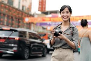 jung asiatisch Frau Rucksack Reisender genießen China Stadt, Dorf Straße Essen Markt im Bangkok, Thailand. Reisender Überprüfung aus Seite Straßen. foto