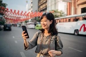 jung asiatisch Frau Rucksack Reisender genießen China Stadt, Dorf Straße Essen Markt im Bangkok, Thailand. Reisender Überprüfung aus Seite Straßen. foto