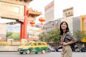 jung asiatisch Frau Rucksack Reisender genießen China Stadt, Dorf Straße Essen Markt im Bangkok, Thailand. Reisender Überprüfung aus Seite Straßen. foto