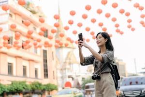 jung asiatisch Frau Rucksack Reisender genießen China Stadt, Dorf Straße Essen Markt im Bangkok, Thailand. Reisender Überprüfung aus Seite Straßen. foto