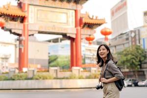 jung asiatisch Frau Rucksack Reisender genießen China Stadt, Dorf Straße Essen Markt im Bangkok, Thailand. Reisender Überprüfung aus Seite Straßen. foto