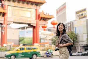 jung asiatisch Frau Rucksack Reisender genießen China Stadt, Dorf Straße Essen Markt im Bangkok, Thailand. Reisender Überprüfung aus Seite Straßen. foto