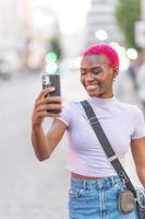 afrikanisch Frau mit Rosa Haar nehmen ein Selfie foto