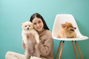 Porträt von jung schön Frau Küsse und Umarmungen ihr Hund Über Grün Hintergrund. foto