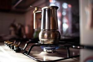 ein Kaffeemaschine auf das Blau Gas Feuer, Herstellung heiß schwarz Kaffee foto