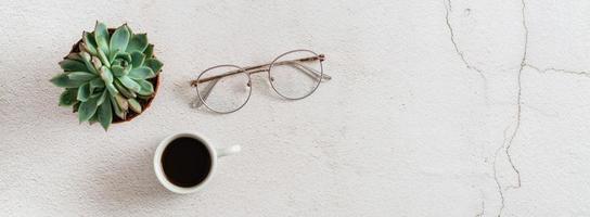 Tasse von Kaffee, Brille und saftig auf ein Licht Hintergrund. Zuhause Arbeitsplatz. Öko Lebensstil. Netz Banner foto