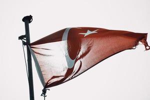 nationales Truthahnsymbol - türkische Flagge auf Post auf Hügelspitze im weißen Hintergrund foto