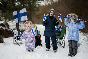 drei finnisch Kinder mit Finnland Flaggen auf ein nett Winter Tag. nordisch skandinavisch Personen. foto