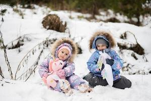 zwei Schwestern im Winter Wald mit ausgestopft Einhorn Spielzeuge. foto