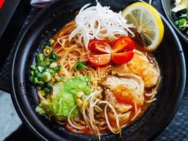 Koreanisch Tomate Ramen mit Fleisch, Gemüse und Nudeln Nahansicht. das Aussicht von das oben foto