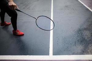 junger Mann, der draußen Badminton spielt foto