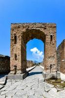 das Caligula Triumph Bogen im uralt Pompeji, Italien. suchen Norden durch das Bogen von Caligula in über di Merkur, von Kreuzung von über delle Begriff, auf links, und über della Glück, auf Rechts. foto