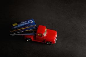 Kreditkarten auf einem kleinen Modell roten Pickup foto