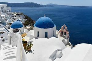 charmant Aussicht oia Dorf auf Santorini Insel, Griechenland. traditionell berühmt Blau Kuppel Kirche Über das Caldera im ägäisch Meer. traditionell Blau und Weiß Kykladen die Architektur. foto