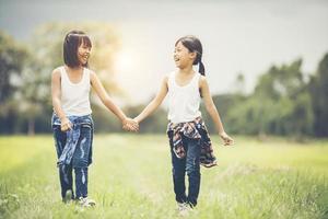 zwei kleine Mädchen, die Spaß im Park haben foto