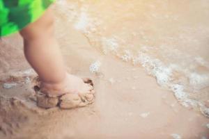 Beine eines Jungen, der am Strand steht foto