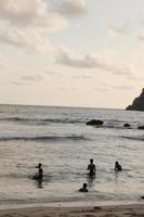 ein Gruppe von klein Kinder versammeln und abspielen auf das Strand im Malang, Indonesien foto