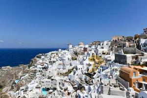 charmant Aussicht oia Dorf auf Santorini Insel, Griechenland. traditionell berühmt Blau Kuppel Kirche Über das Caldera im ägäisch Meer. traditionell Blau und Weiß Kykladen die Architektur. foto