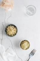 frisch Kleeblatt und Alfalfa Sprossen zum Essen im ein Schüssel und ein Glas von Wasser auf ein Licht Tisch. Entgiftung organisch Diät. oben und Vertikale Aussicht foto