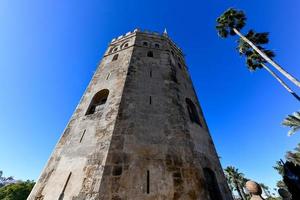 golden Turm oder torre del Oro mit Palme Bäume, ein mittelalterlich Militär- Steuerung Turm auf Flussufer von Sevilla, Andalusien, Spanien. foto