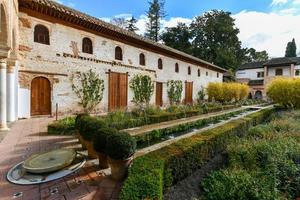 Aussicht von das verallgemeinern Hof, mit es ist berühmt Brunnen und Garten durch ein Bogen. Alhambra de Granada Komplex beim Granada, Spanien, Europa auf ein hell Winter Tag. foto