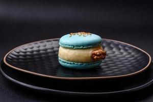 schön lecker Macaron mit Füllung und Obst Geschmack auf ein schwarz Teller foto