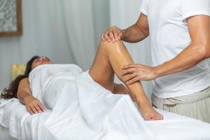 Therapeut tun ein Bein Massage zu Frau im Spa Salon foto