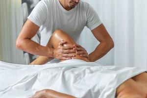 schließen oben Aussicht von ein männlich Masseuse tun ein Bein Massage zu Frau auf Massage Tabelle im ein Spa Salon foto