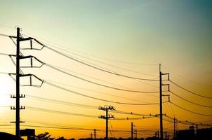 Silhouette von elektrisch Pole mit Kabel auf dramatisch Sonnenuntergang Himmel, horizontal Rahmen foto