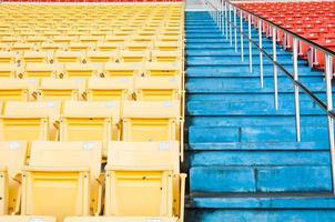 leere orangefarbene und gelbe sitze im stadion, sitzreihen in einem fußballstadion foto